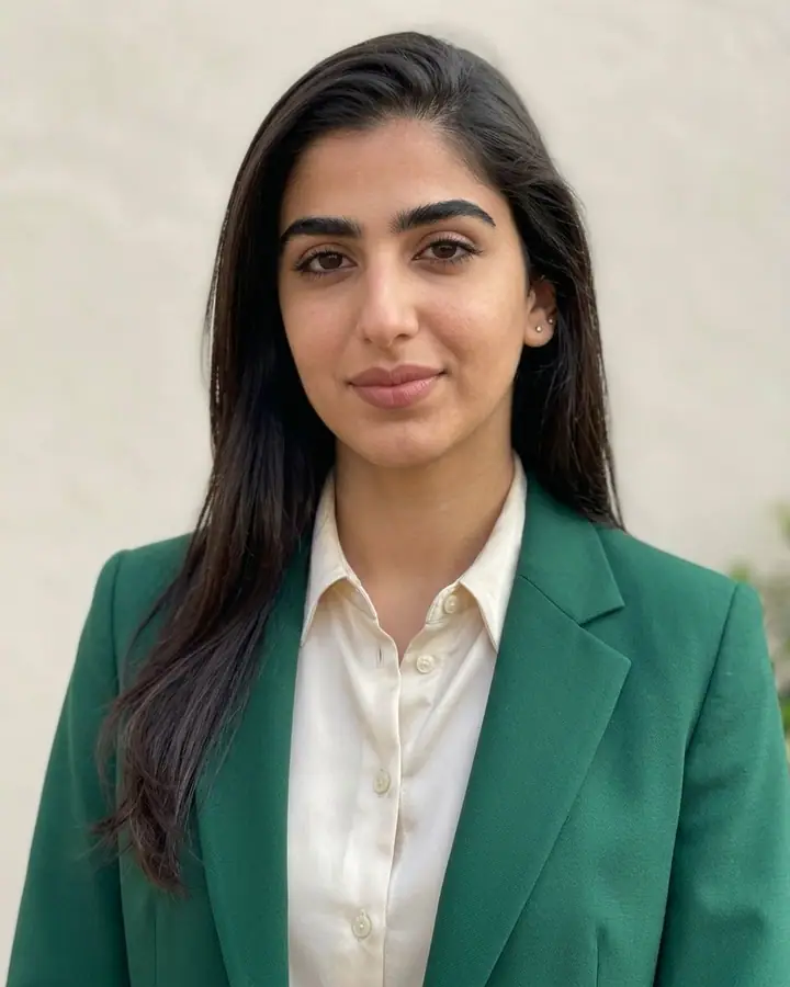 AI example of a photo edit that swaps a woman's outfit for an emerald green suit