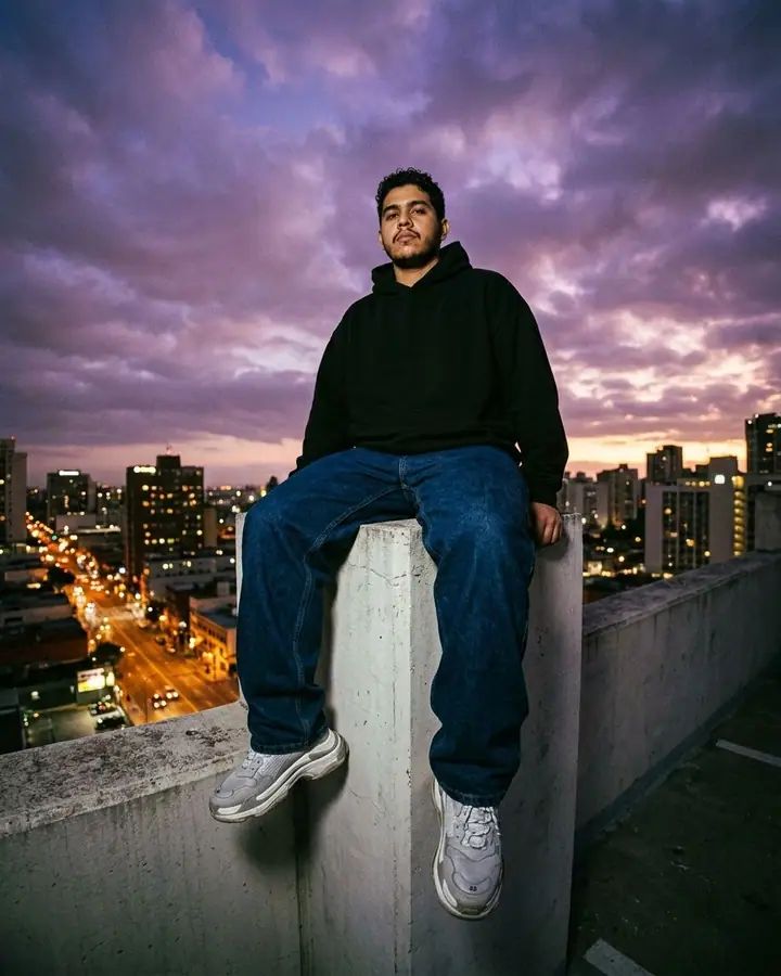 AI example of a man in an oversized hoodie on a city rooftop at dusk