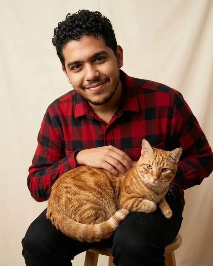 AI example of a man in a studio portrait holding an orange tabby cat on his lap