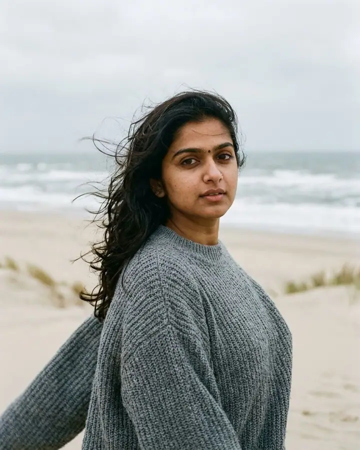 AI example of a windswept overcast beach portrait of a woman in a knit sweater