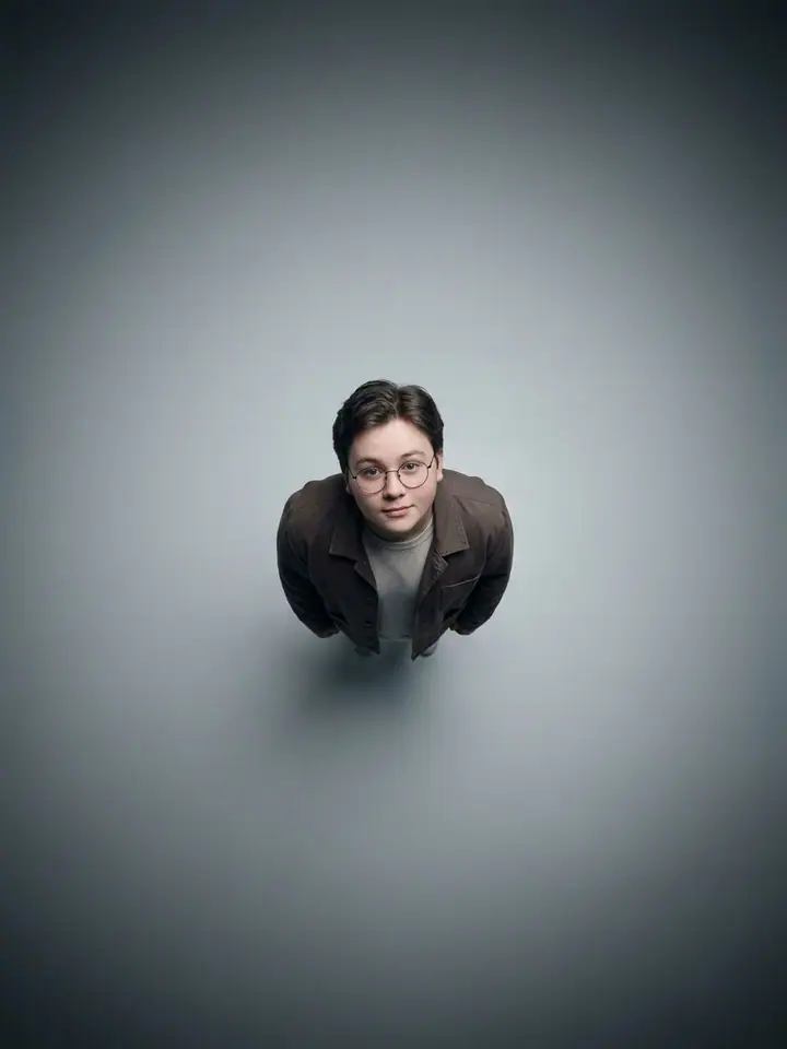 Man in glasses photographed from directly above, looking up at the camera