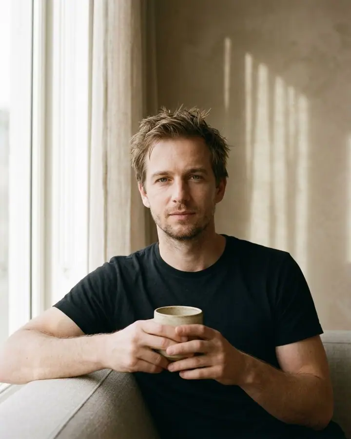 AI example of a soft window-light editorial portrait of a man holding a ceramic cup